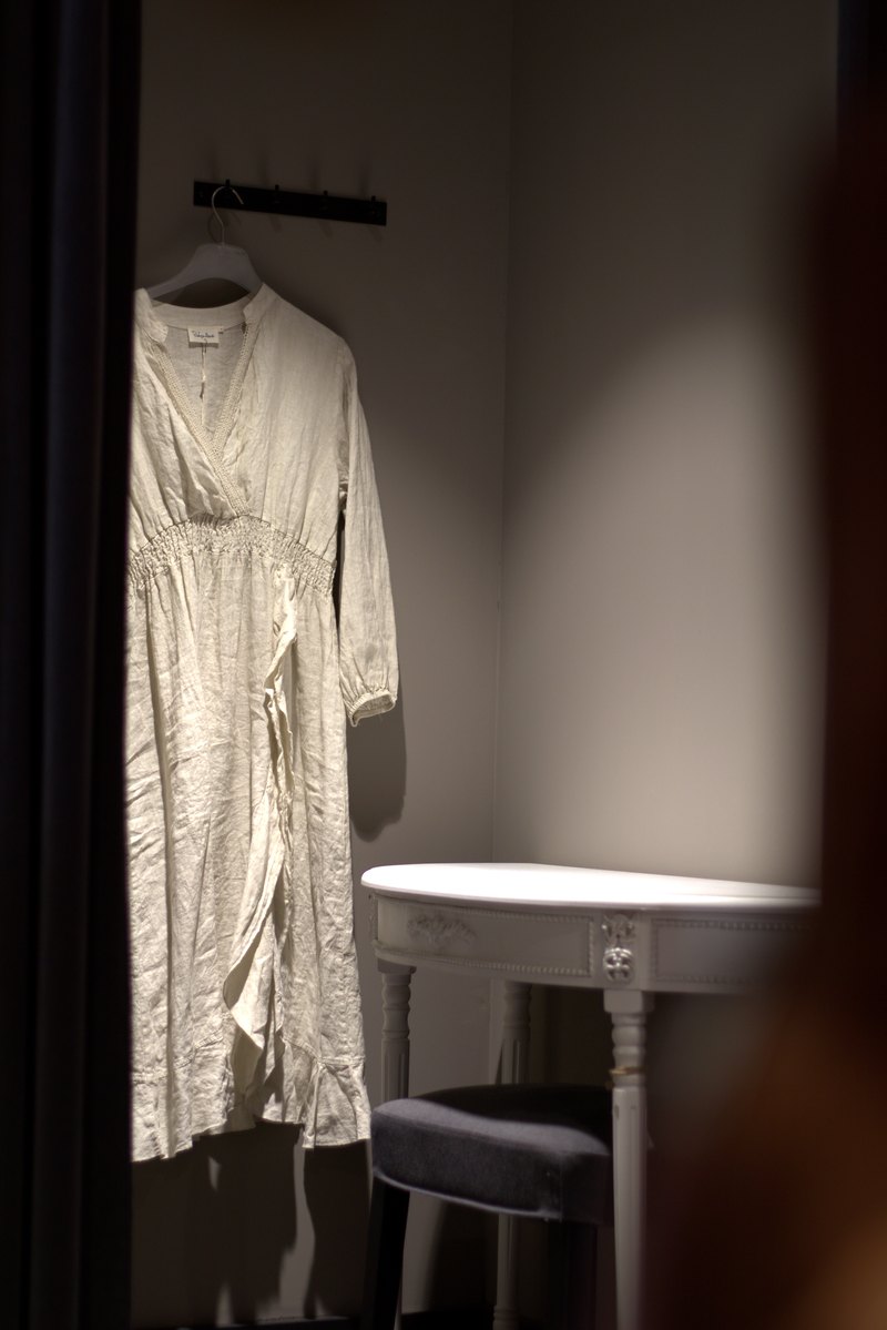 Helles Leinenkleid auf einem Bügel